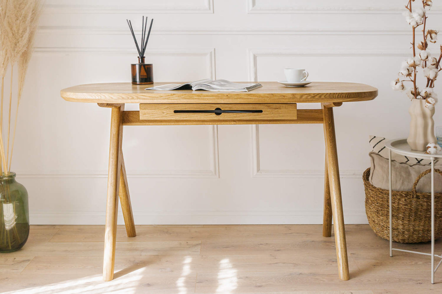 Can successfully be used as  for makeup desk in bedroom or even wooden office desk, wooden desk with drawers with drawer under desk or solid oak desk for home office also known as writing desk. Front view of handmade furniture standing on wooden floor with the magazine on top and cup of coffee.