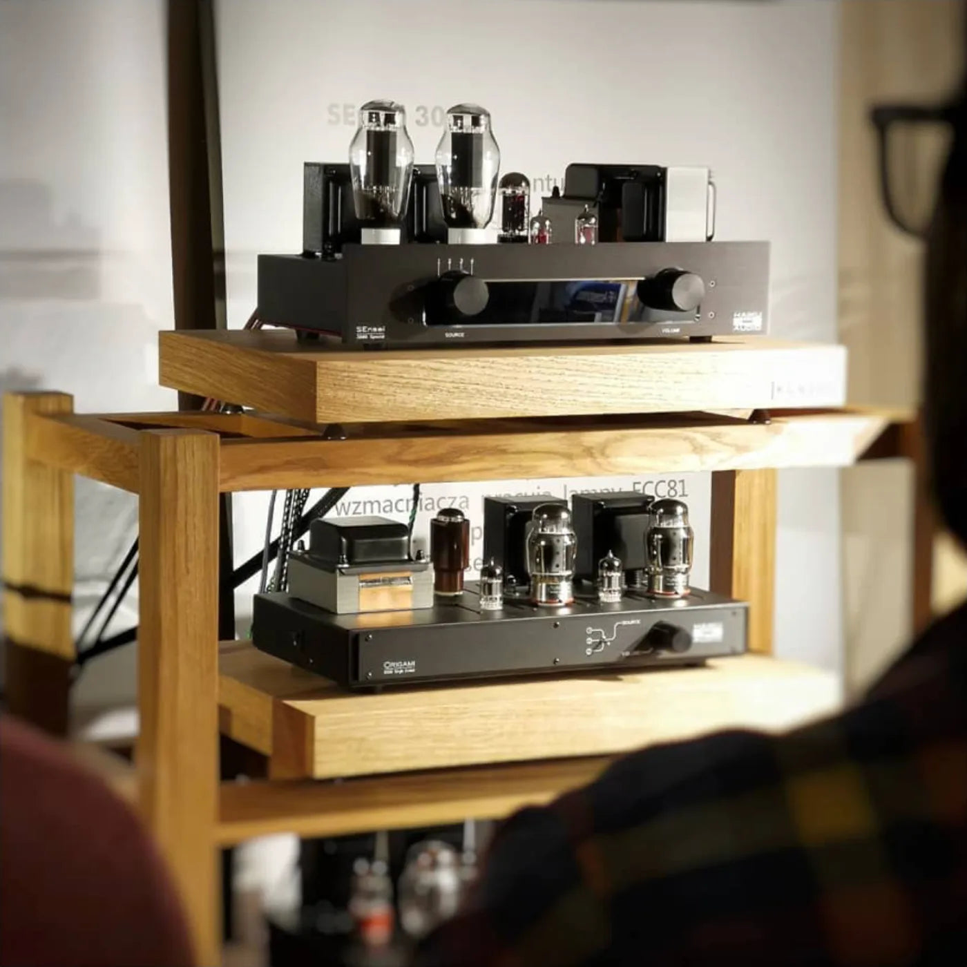 Wooden hifi amp and turntable stands in listening room with turntable on top and haiku amplifiers on shelves