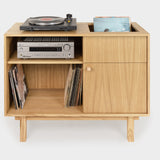A solid oak vinyl record cabinet with a turntable on top and a small shelf with amplifier