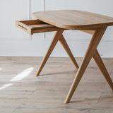 Kunsst wooden writing desk can successfully be used as  for makeup desk in bedroom or even wooden office desk, wooden desk with drawers with drawer under desk or solid oak desk for home office. Angled view of writing desk with drawer opened. 