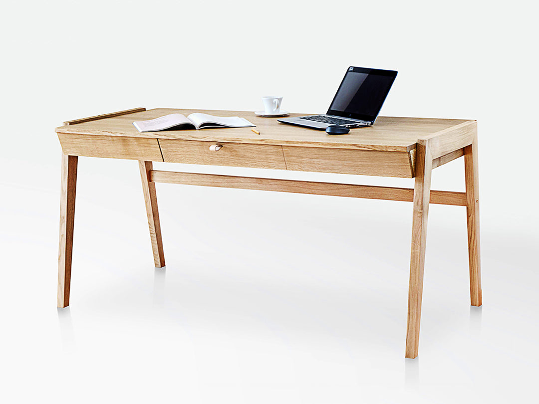 The KUNSST FURNITURE Solid Oak Desk with Drawer - Model_No.01 is set against a plain white background, highlighting its traditional woodworking craftsmanship. On the desk's surface, an open book, a cup, and a laptop evoke a sense of productivity and tranquility.