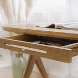 Kunsst solid wooden desk with a drawer open, showing a magazine inside, standing in a vanity room.