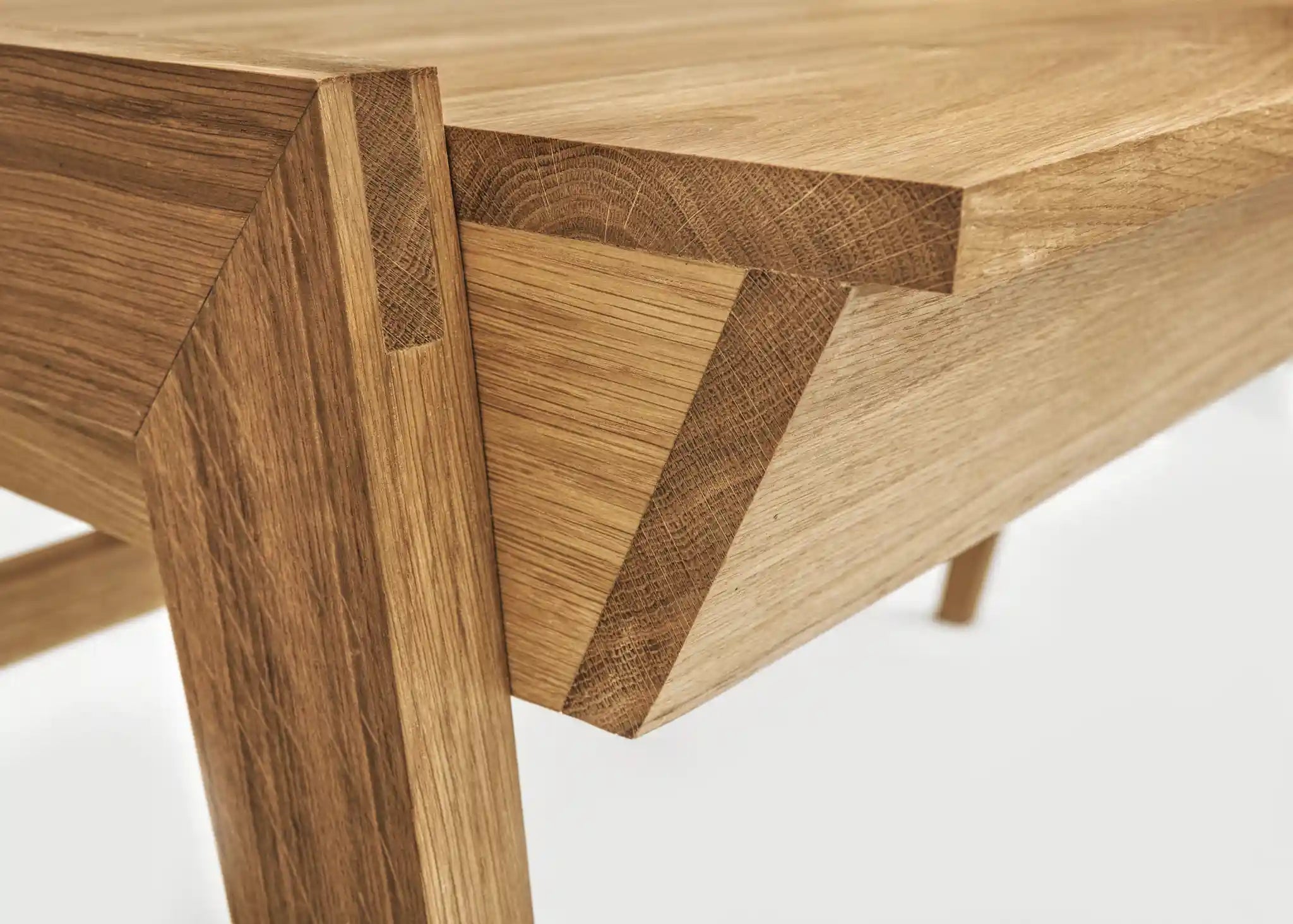 Close-up of a wooden desk with drawer with visible oak grain and joint details on a white background 