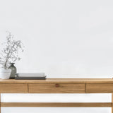 Front view of solid wood desk with drawer, crafted from premium oak with a vase and branches on a white background