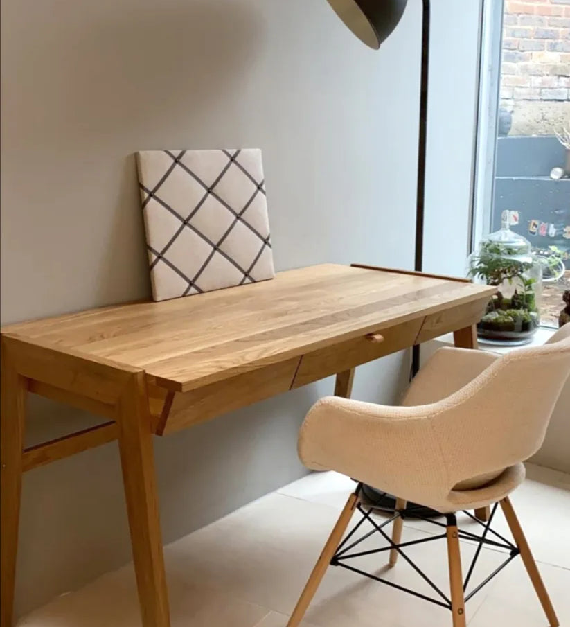 Luxury solid wood desk with a drawer in a living room with a window, a chair and plant. 